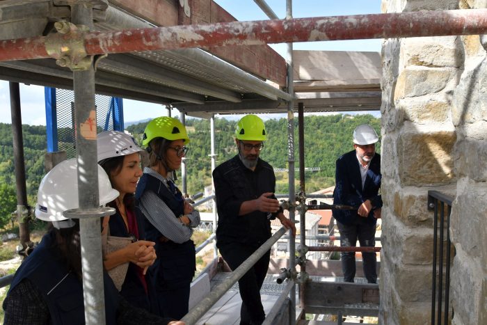 Cittadini in visita alla Torre Civica di Amatrice; l’orologio fermo alle 3:36 riparte